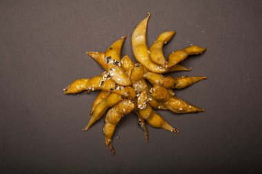 Gri arka planda kabuklu kızarmış yeşil bezelyeler.