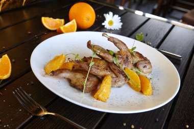 Beyaz tabakta kızarmış bıldırcın eti.