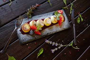 Böğürtlenli ve meyveli cheesecake şeklinde tatlı.