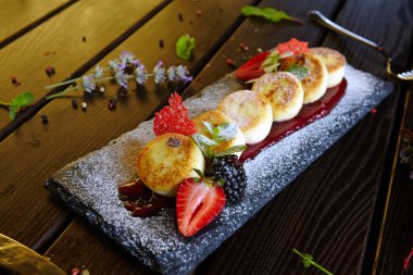 Böğürtlenli ve meyveli cheesecake şeklinde tatlı.