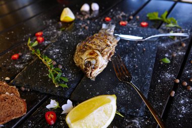 Siyah tahtada limonlu kızarmış balık.