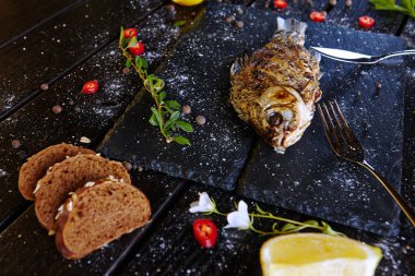 Siyah tahtada limonlu kızarmış balık.