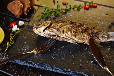 Siyah tahtada limonlu kızarmış balık.