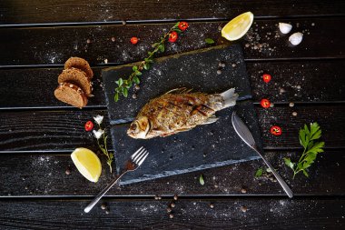 Siyah tahtada limonlu kızarmış balık.
