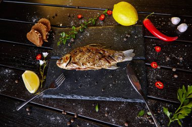Siyah tahtada limonlu kızarmış balık.
