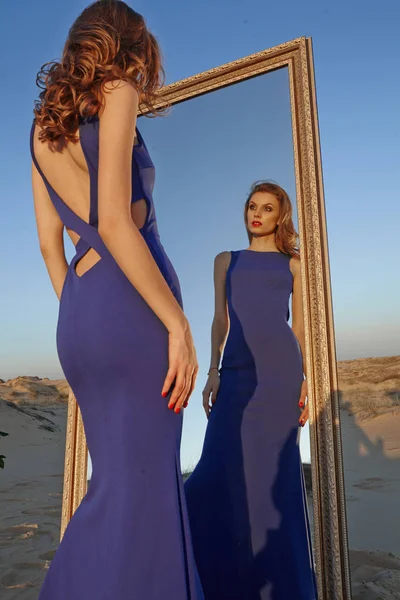 woman in the desert with a big mirror