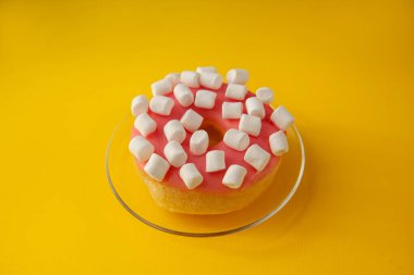 Pembe kremalı çörek ve sarı arka planda lokum.