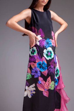 Stüdyoda saçları güzel bir elbiseyle gri arka planda bir kadın manken.