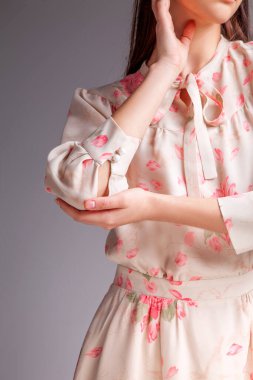 Stüdyoda saçları güzel bir elbiseyle gri arka planda bir kadın manken.