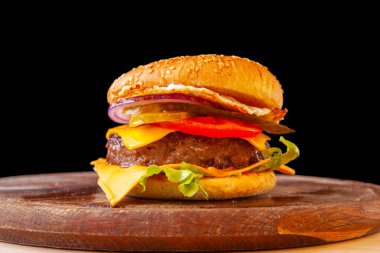 Peynirli taze hamburger, yeşil et ve domates.