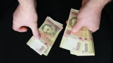 İçerideki bir adam onları elinde tutarak para sayar.