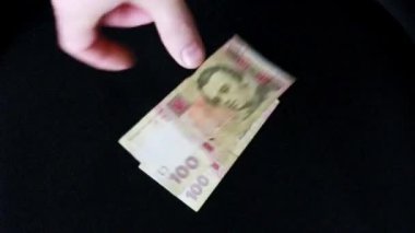 İçerideki bir adam onları elinde tutarak para sayar.