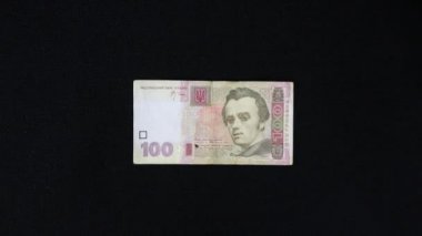 Adamın eli siyah arka planda duran bir banknotu alır.