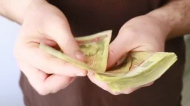 İçerideki bir adam onları elinde tutarak para sayar.
