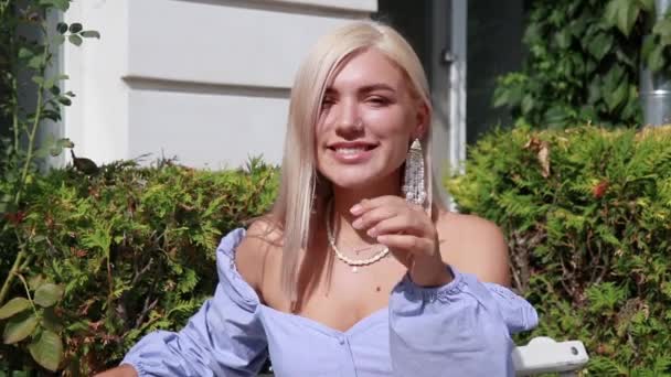 Mujer Rubia Con Pelo Sentado Banco Calle — Vídeos de Stock