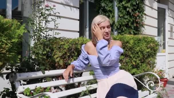 Femme Blonde Avec Ses Cheveux Assis Sur Banc Dans Rue — Video