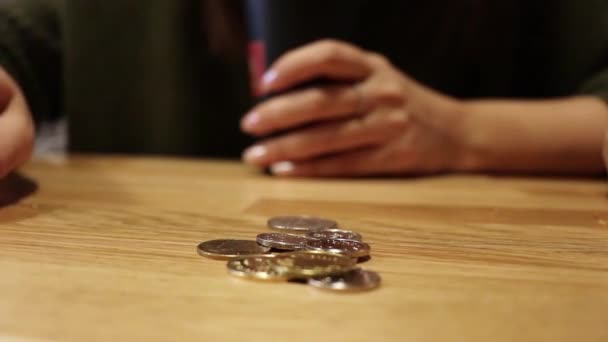女性はテーブルに座りながらコインを数える — ストック動画