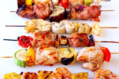 Ahşap şişler üzerinde ızgara deniz ürünleri eti pastırması.