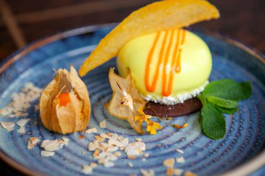 Mavi tabakta güzel dekore edilmiş bir tatlı.