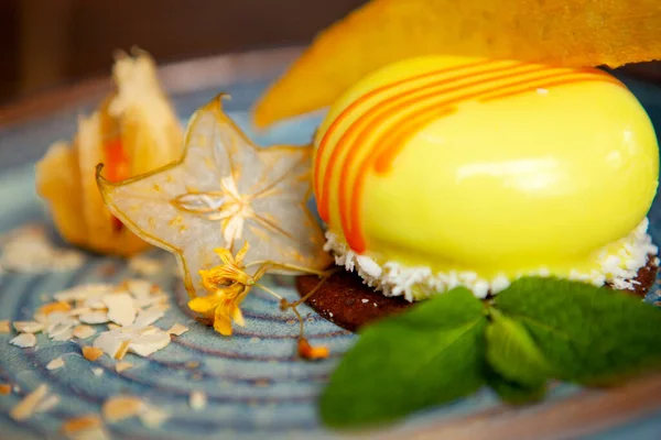 Mavi tabakta güzel dekore edilmiş bir tatlı.