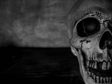 Yarım yüz doku üzerinde karanlık çimento arka plan korku kavramı ile insan kafatası