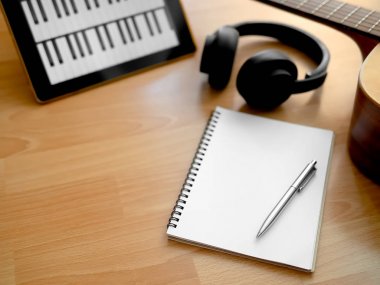 Müzik oluşturma araçları, kulaklık, gitar, Notebook, elektronik Tablet ve kalem ahşap arka plan üzerinde