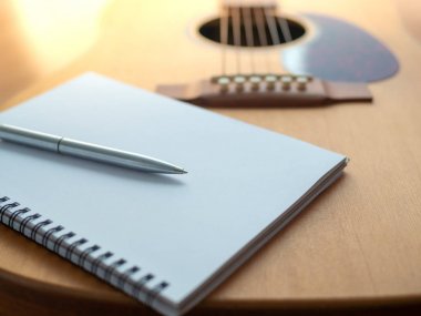 Müzik oluşturma araçları, gitar, defter ve kalem ahşap arka plan üzerinde