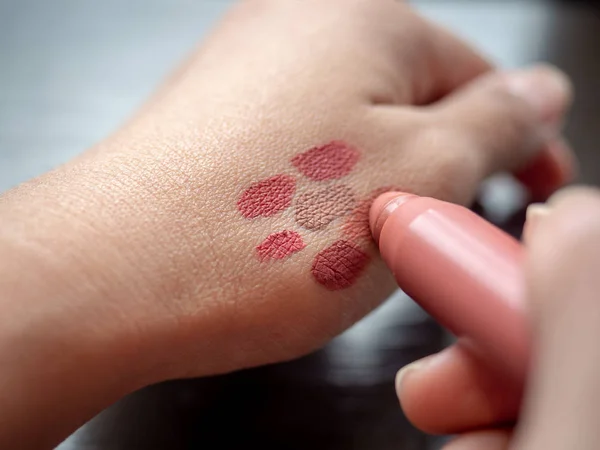 Руки жінки тестують кольори помади на шкірі . — стокове фото
