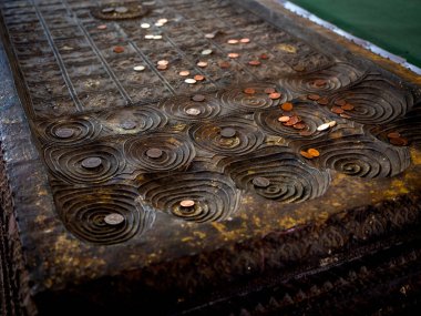 Tapınaktaki Buda ayak izinin kopyasına bir sürü bozuk para yerleştirildi..