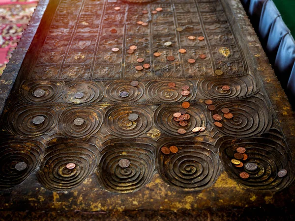 Molte monete collocate sulla replica dell'impronta buddha nel tempio . — Foto Stock