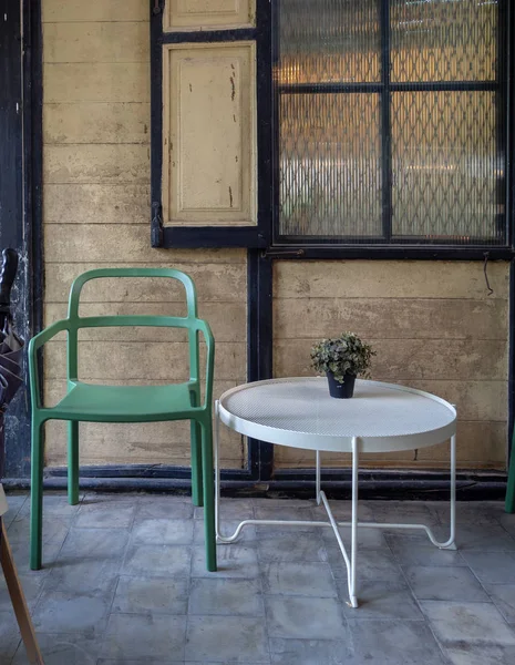 Cadeira verde moderna e mesa redonda branca com planta verde em vas — Fotografia de Stock