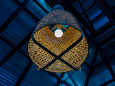 Geleneksel el yapımı bambu tavan lambası ya da camdan ev inşaatında tavandan sarkan ampul. Retro ışıklandırma dekorasyonu.