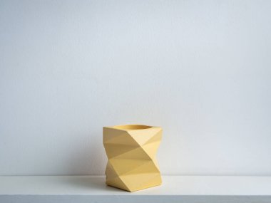 Kaktüs tenceresi. Beton çömlek. Beyaz arka planda izole edilmiş beyaz ahşap raftaki boş sarı, modern geometrik beton ekicisi.