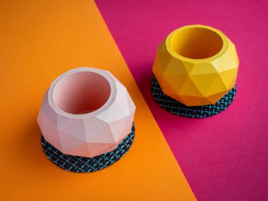 Kaktüs tenceresi. Beton çömlek. Renkli arka planda boş pembe ve turuncu modern geometrik beton ekiciler, üst görünüm.