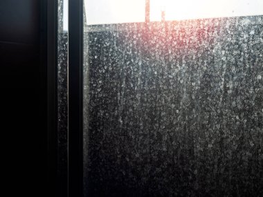 Tozlu ve kirli cam kapı. Banyodaki sürgülü kapıda su lekesi, koyu arka plan..