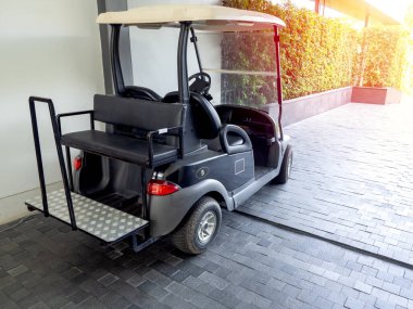 Siyah golf arabası ya da golf arabası müşteriler için otel servisine park edilmiş..