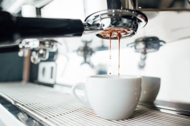 Beyaz bardaktaki dipsiz iskeleden espresso özütü.