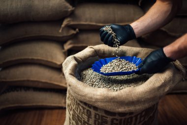 Çuval bezi çantasından kahve dolduran el manzarası