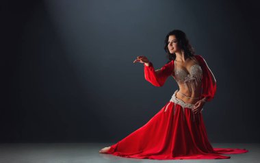 Kırmızı Arap elbiseli kadın ahırlarda dans ediyor.