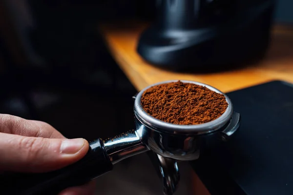 Portafilter pieno di caffè macinato in una mano — Foto Stock