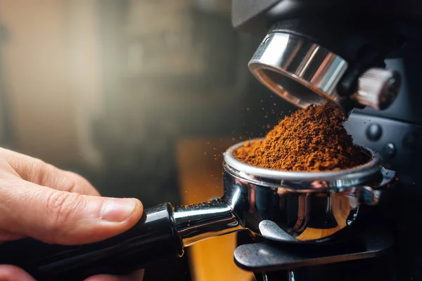 Gemahlener Kaffee, der mit einer Mühle in einen Portafilter gegossen wird — Stockfoto
