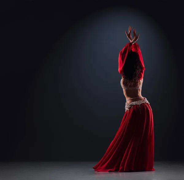 Hermosa chica de pelo negro en un vestido étnico rojo en la danza del escenario — Foto de Stock