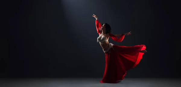 Kırmızı Arap elbiseli kadın oryantal dansçı Arabesk pozu veriyor. — Stok fotoğraf