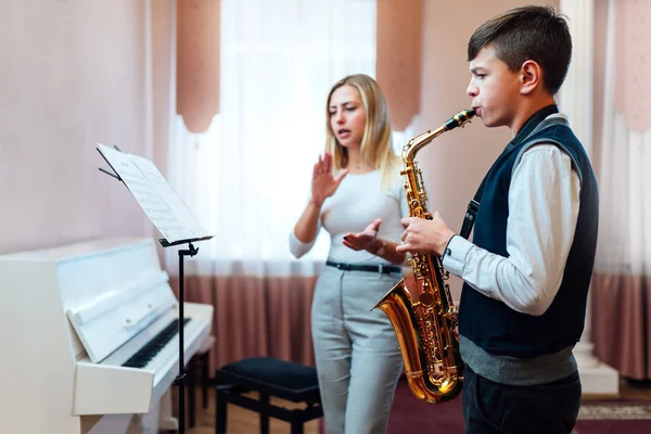 Lärare klappar istället för en metronome för en student på saxofon — Stockfoto