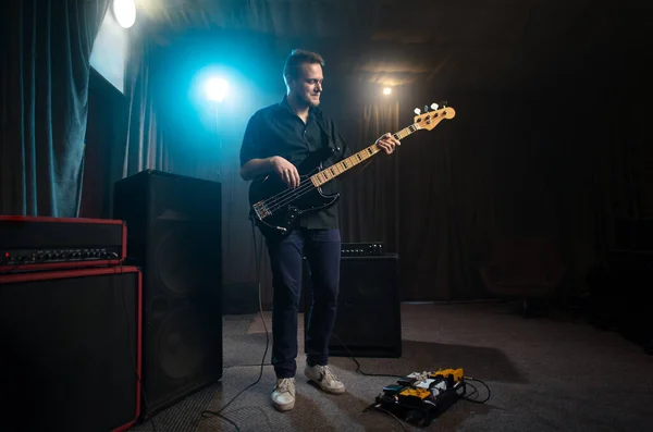 Muzikant speelt een elektrische basgitaar op het podium — Stockfoto