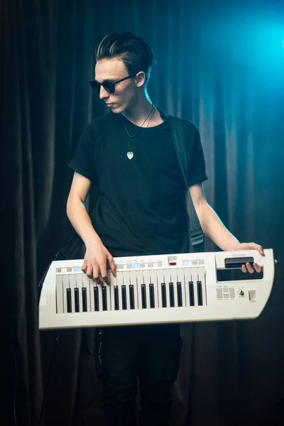 Модный молодой человек играет на электронной клавиатуре — стоковое фото