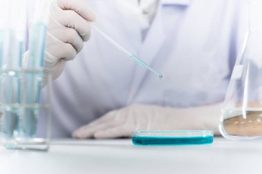 Bilim adamının elinde deney tüpleri, bilim ve tıbbi araştırma ve geliştirme konseptine kimyasal sıvı damlatan matara.