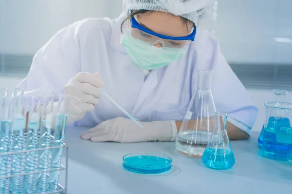 Asyalı kadınlar bilim adamı ile test tüpü içinde klinik laboratuvar araştırma yapma. Bilim, kimya, teknoloji, biyoloji ve insanlar kavramı