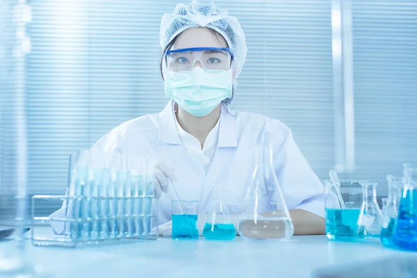 Asyalı kadınlar bilim adamı ile test tüpü içinde klinik laboratuvar araştırma yapma. Bilim, kimya, teknoloji, biyoloji ve insanlar kavramı