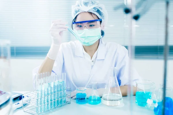 Asyalı kadınlar bilim adamı ile test tüpü içinde klinik laboratuvar araştırma yapma. Bilim, kimya, teknoloji, biyoloji ve insanlar kavramı